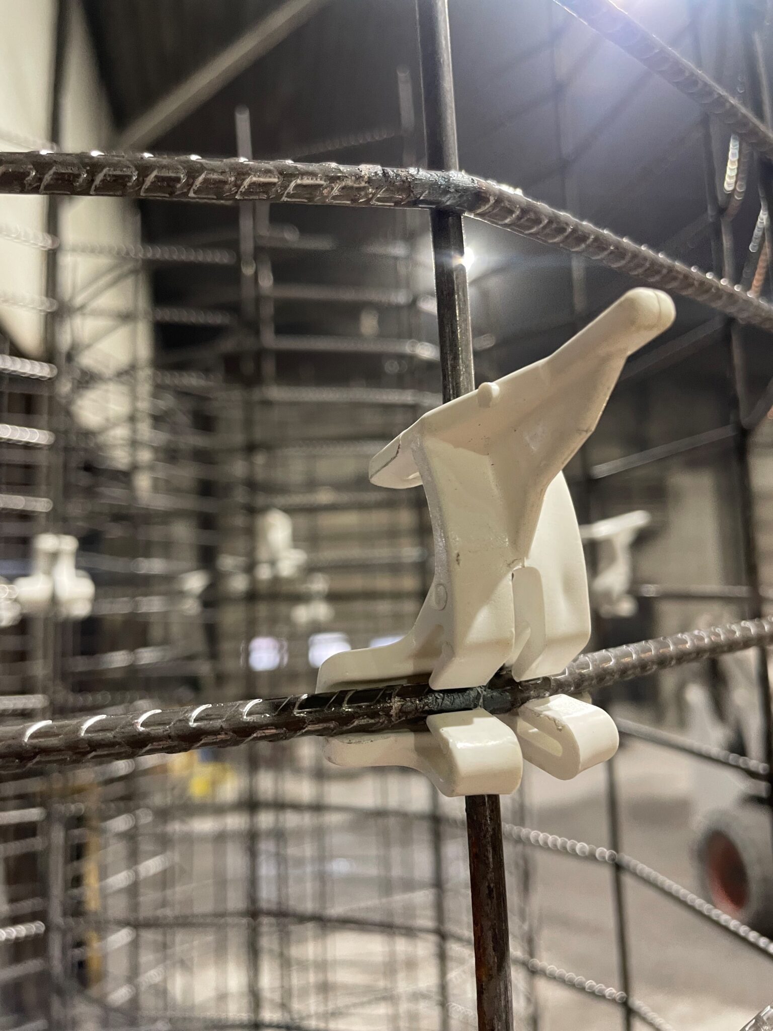 Figurine blanche sur structure métallique industrielle.