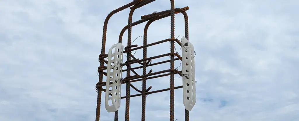 Espaceurs pour pieux Plasti-Tom sur structure métallique avec nuages en arrière-plan.