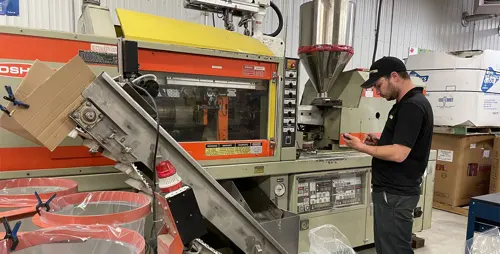 Homme inspectant machine industrielle en fonctionnement.