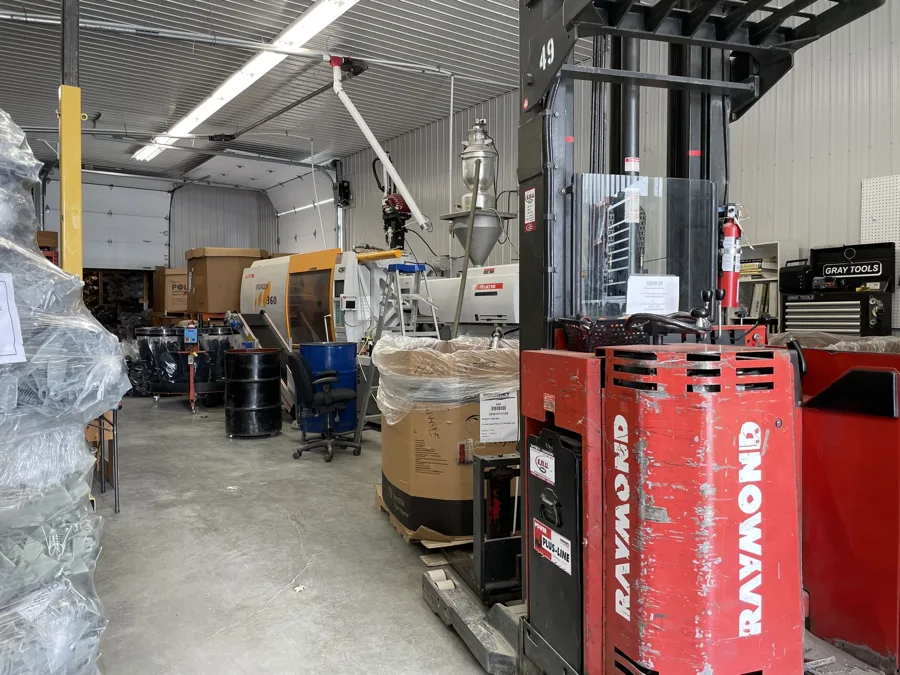 Entrepôt industriel avec matériel et chariot élévateur.