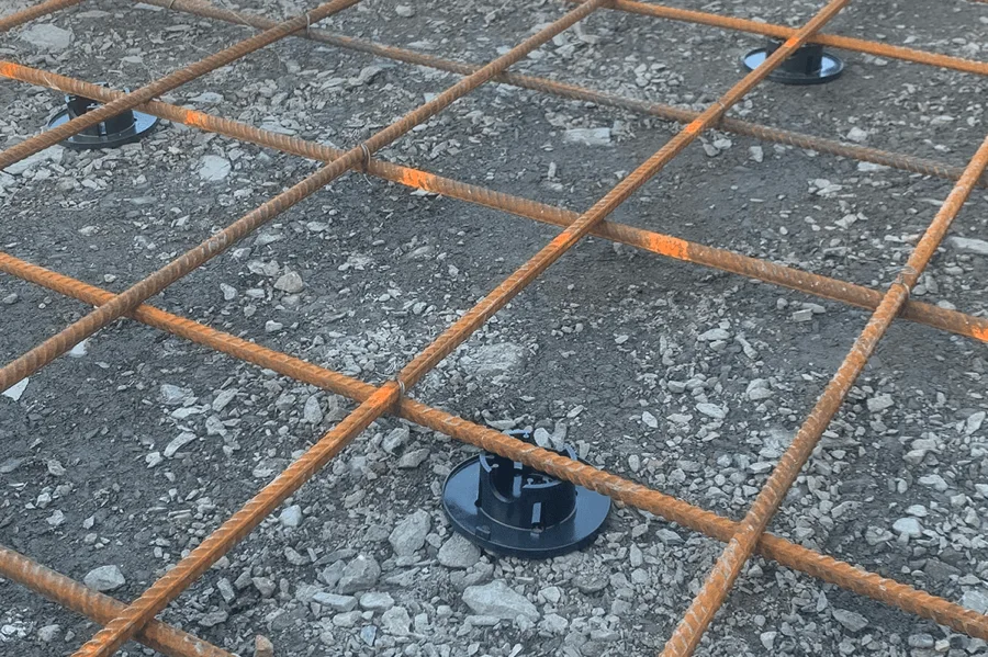 Grillage métallique sur sol gravier, supports Plasti-Tom visibles.